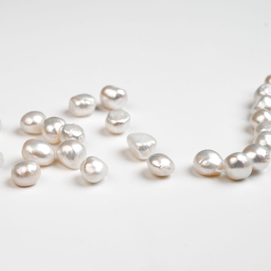 Pearl necklace with loose pearls on a light background